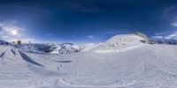 a panoramic view of some people skiing down the slopes of a mountain in winter