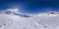 a person on skis is skiing up a snow covered mountain hill under a sun