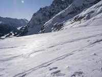 the person is skiing down the snow covered mountain slope and is in the sun looking forward