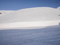 a person skiing in the snow by a mountain shoreline in the winter season,