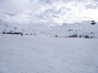 many people on skis and snowboards on the slopes near a gondola lift