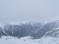 a skier skiing up a mountain with many snowcapped mountains in the background in winter