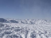 a person skiing on the snow covered slopes in a mountain landscape with mountains in the distance