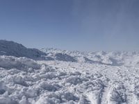 a person skiing on the snow covered slopes in a mountain landscape with mountains in the distance