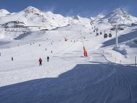 the snow is white and full of people skiing down a hill side near a lift