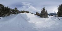 a person in skis is flying through the air over snow covered hills and trees