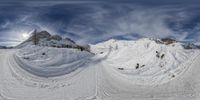 a panorama image of skis and snow - capped mountains in the background with clouds