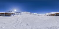 a 360 - lens photo shows some snow on the ground and people at the top of the hill