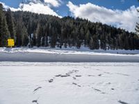 a person wearing skis on a snow covered field in the woods above mountains with a sign that reads beware of all others