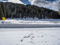 a person wearing skis on a snow covered field in the woods above mountains with a sign that reads beware of all others