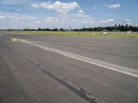 the empty runway of an airplane runway, with only a single car parked on it