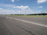 the empty runway of an airplane runway, with only a single car parked on it