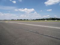 the empty runway of an airplane runway, with only a single car parked on it