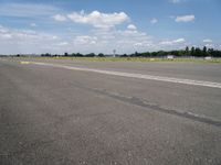 the empty runway of an airplane runway, with only a single car parked on it