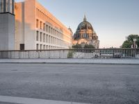 an empty street next to two tall buildings with domes in the background is an older building