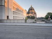 an empty street next to two tall buildings with domes in the background is an older building