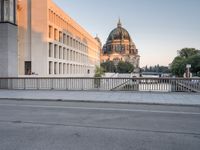 an empty street next to two tall buildings with domes in the background is an older building