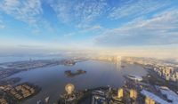 a city that includes a huge body of water and buildings at sunset in the evening