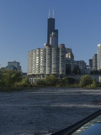 the skyscraper building with a huge amount of windows in it is standing alone and surrounded by trees