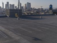 an empty parking lot that contains several lines and blocks in the city skyline in a shadow