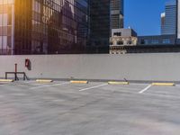 an empty parking lot next to a tall building, with no one standing in the shade