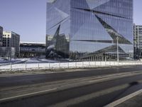 the buildings are in a large city in front of a street that has a curve