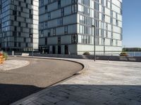 two buildings that are in front of each other and on the ground is a street with brick pavements