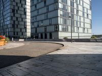 two buildings that are in front of each other and on the ground is a street with brick pavements