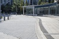 a person sitting at the bench in front of a mall that is empty of people