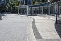 a person sitting at the bench in front of a mall that is empty of people