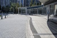 a person sitting at the bench in front of a mall that is empty of people