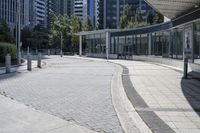 a person sitting at the bench in front of a mall that is empty of people