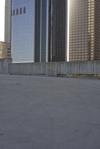 a group of skyscrapers near a bench in the city park with a skate board