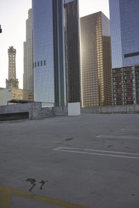 a group of skyscrapers near a bench in the city park with a skate board