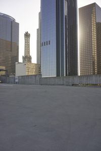 a group of skyscrapers near a bench in the city park with a skate board