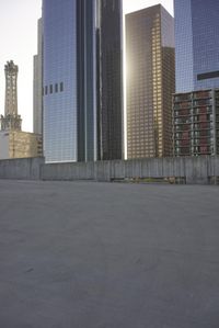 a group of skyscrapers near a bench in the city park with a skate board
