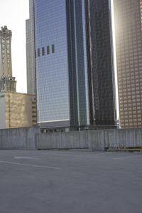 a group of skyscrapers near a bench in the city park with a skate board