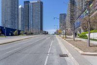 a deserted street surrounded by tall buildings on the other side of it with a stop sign