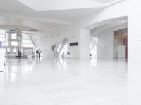 a large open lobby with high ceilings and floor to ceiling windows above the room is white porcelain