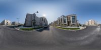 a photo of an empty street with buildings on both sides and cars parked in the lot