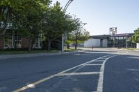 the intersection of a street in front of a building with lots of trees and shrubs