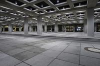 the view inside of an empty building at night time with traffic on it and empty streets in the background