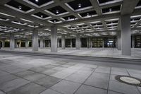 the view inside of an empty building at night time with traffic on it and empty streets in the background