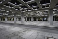 the view inside of an empty building at night time with traffic on it and empty streets in the background