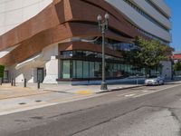 the car is parked on the side of the street near the street light and the building