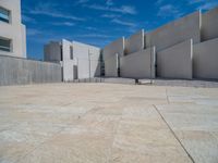 the gray concrete walls of a building have a line of steps on the left side