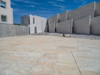 the gray concrete walls of a building have a line of steps on the left side