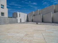 the gray concrete walls of a building have a line of steps on the left side