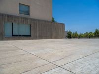 the gray concrete walls of a building have a line of steps on the left side