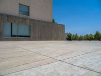 the gray concrete walls of a building have a line of steps on the left side